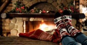 Woman legs with socks and christmas fireplace