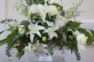 White funeral flowers with greenery